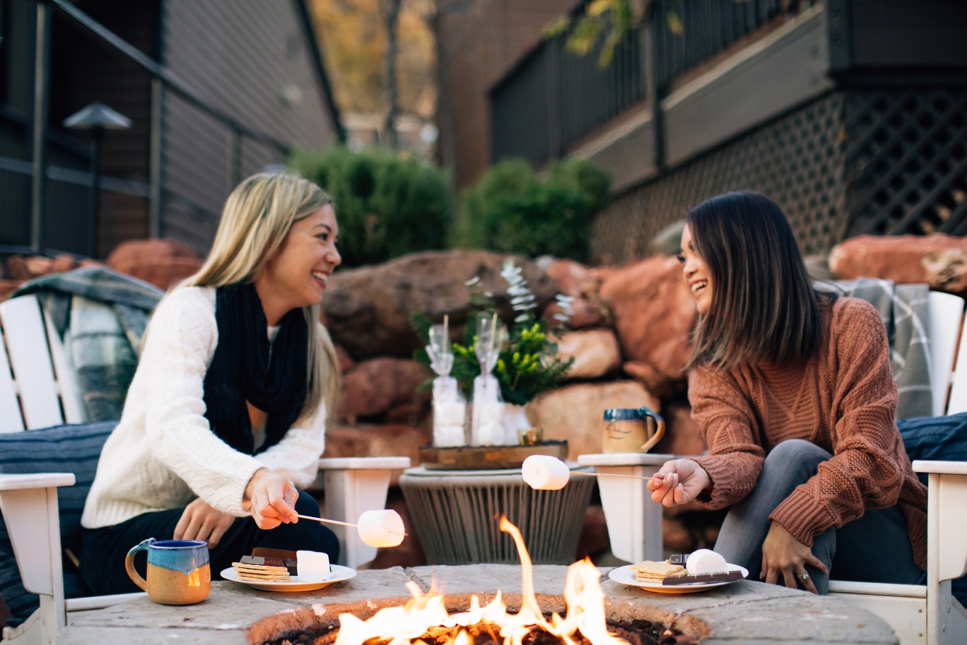 Two women around fireplace with s'mores
